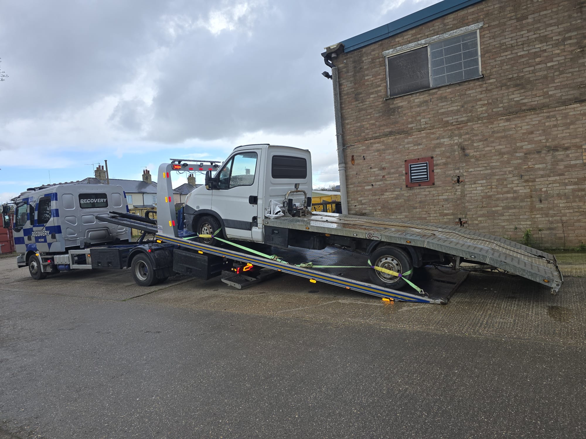 Recovery truck transporting a large white van