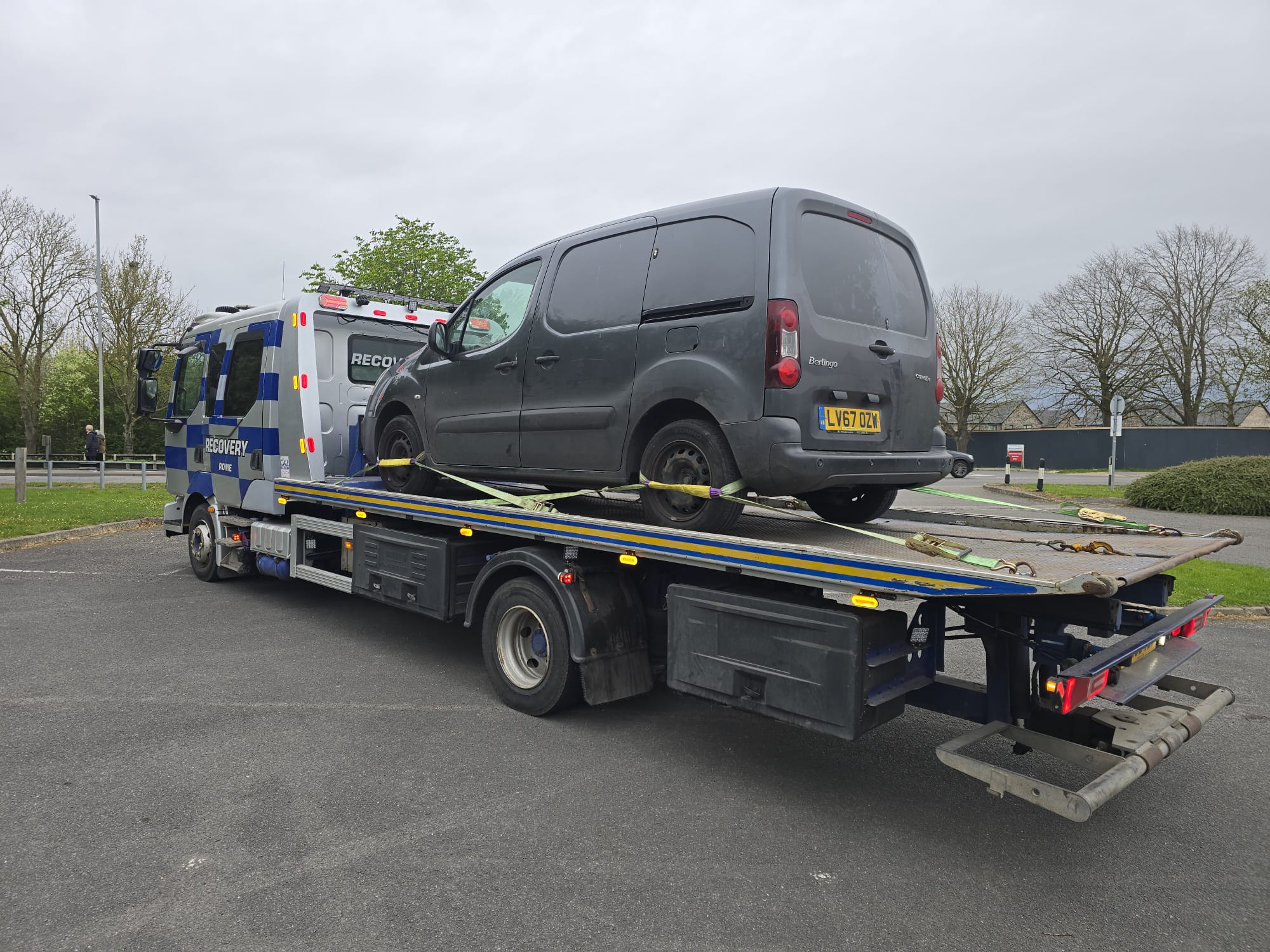 Recovery truck carrying a grey Nissan Qashqai from the rear