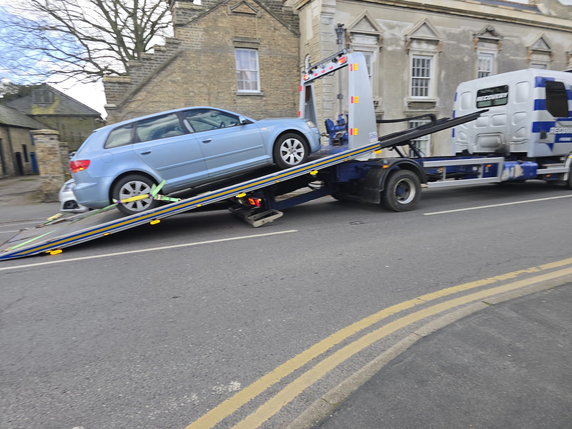 Recovery truck transporting a classic cream and brown car