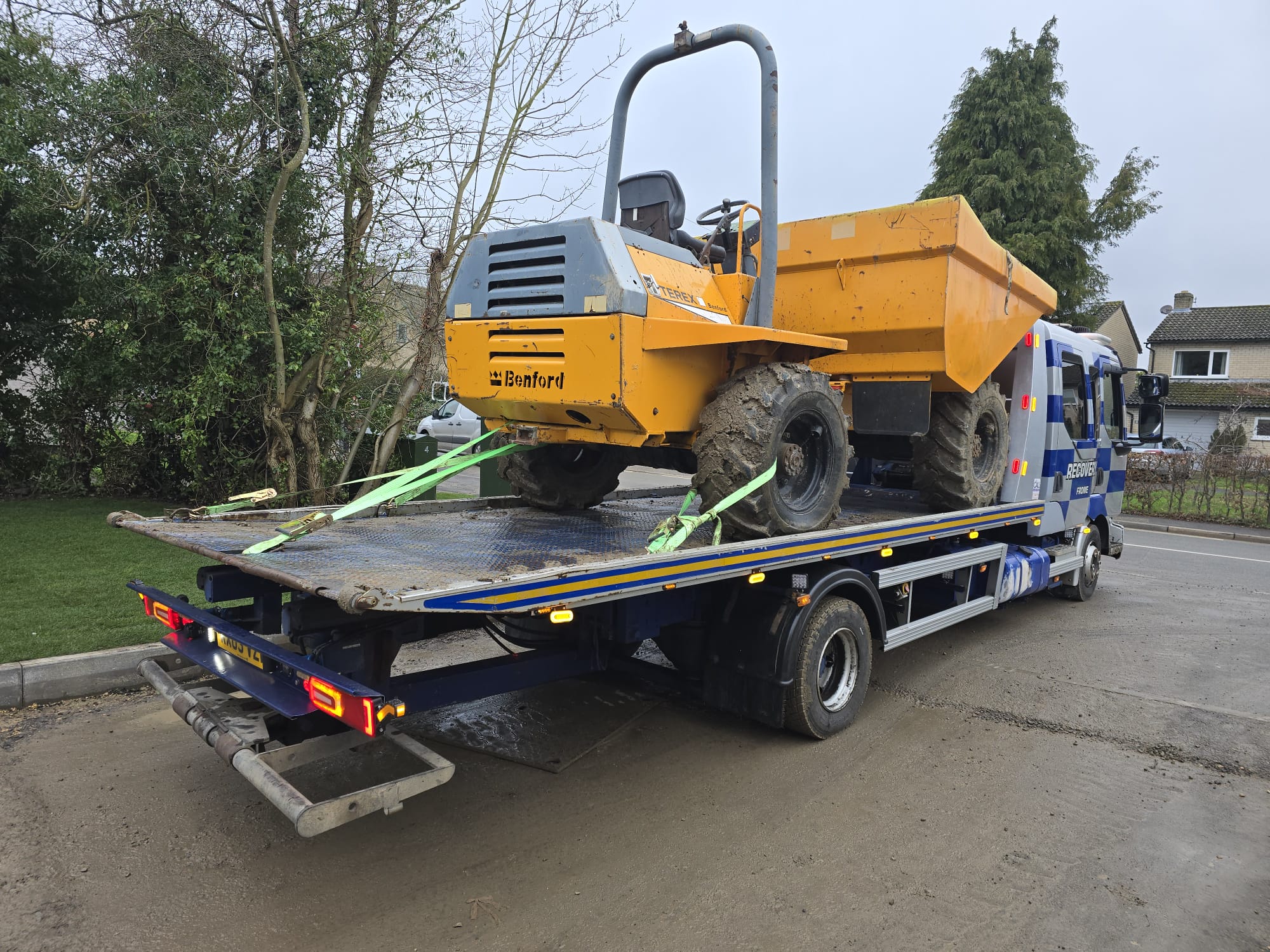 Recovery truck loading a white flatbed vehicle