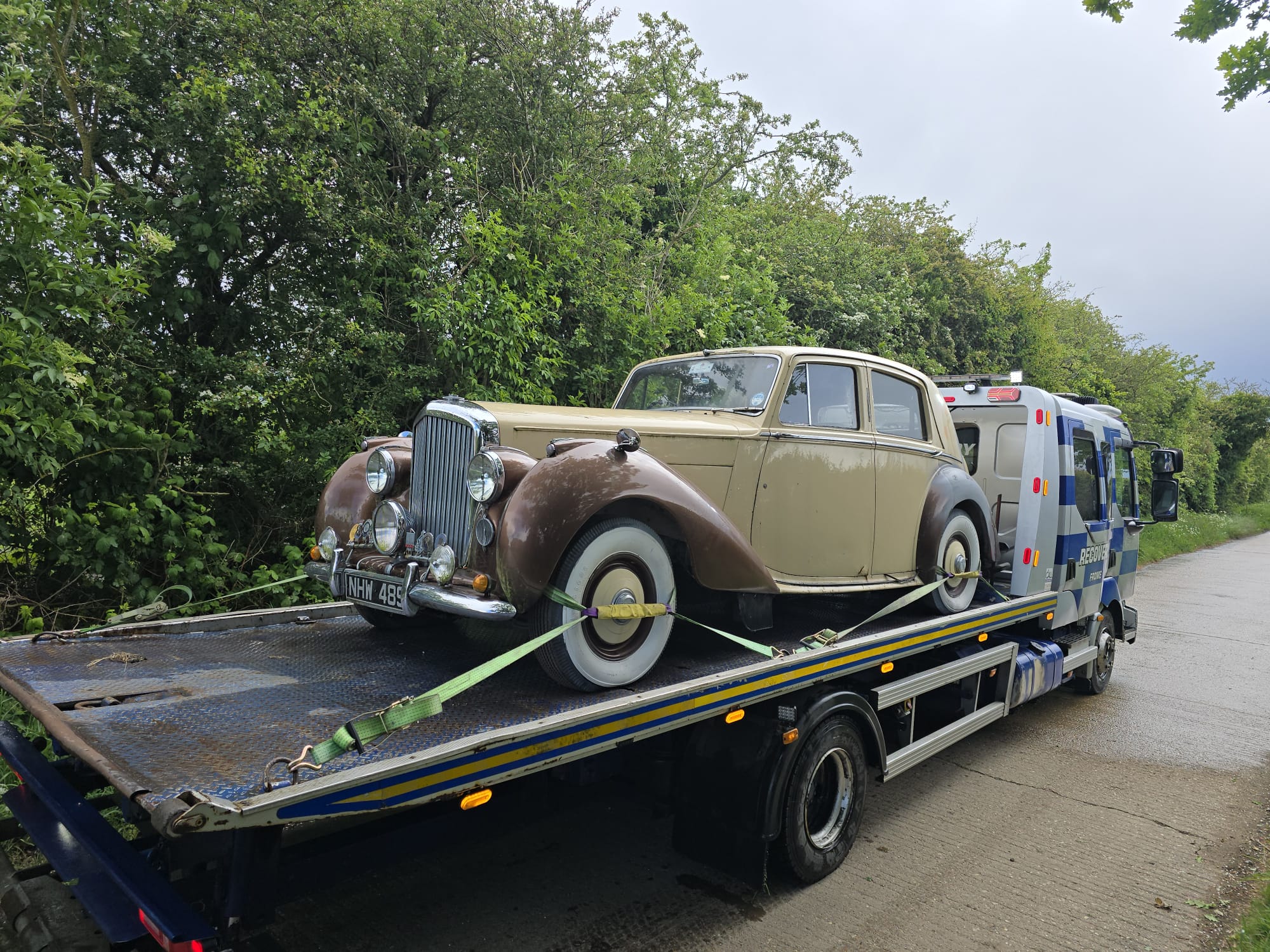 Recovery truck carrying a black Audi car in a car park